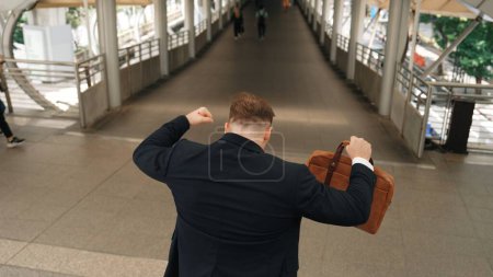 Photo for Businessman walking down stair and hurry to walking back to home. Back view of business people wearing suit and celebrate for getting promotion or increasing sales while holding his suitcase. Urbane. - Royalty Free Image