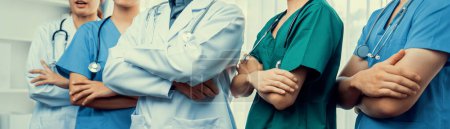 Photo for Confident and professional team of medical staff stand in line together as healthcare service and doctor leadership at hospital background. Teamwork lead to successful medical treatment.Panorama Rigid - Royalty Free Image