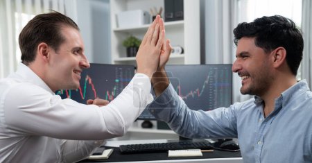 Photo for Cheerful two smiling stock traders giving high five on panorama view to success of digital technology in dynamic data monitor background. Achievement investors in business at workplace. Sellable. - Royalty Free Image
