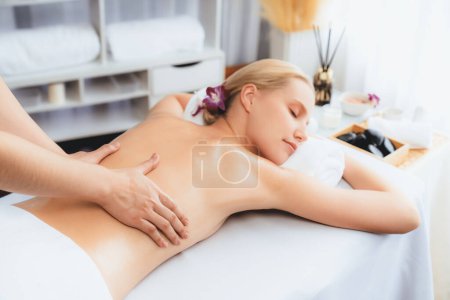 Foto de Cliente mujer caucásica disfrutando de un relajante masaje de spa anti-estrés y mimos con belleza recreación de la piel de ocio en el spa salón ambiente luz del día en un resort de lujo u hotel. Silencioso. - Imagen libre de derechos