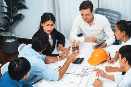 Photo for Diverse group of civil engineer and client working together on architectural project, reviewing construction plan and building blueprint at meeting table. Prudent - Royalty Free Image