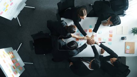 Photo for Top down aerial view of professional investor team putting hand together. Skilled diverse business team to celebrate successful project at meeting table with sticky note. Love and unity. Directorate. - Royalty Free Image