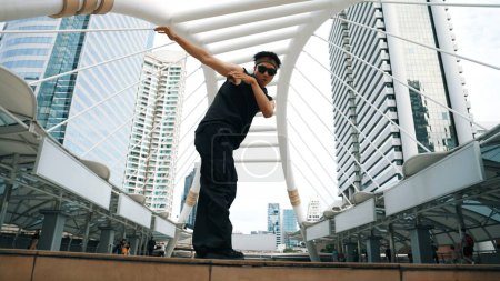 Photo for Young asian hipster show footstep at city center surround by people. Stylish fashion street dancer perform B-boy or freestyle dancing with low angle. Outdoor sport 2024. Break dancing. Sprightly. - Royalty Free Image