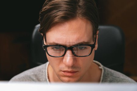 Photo for Portrait stressful businessman wearing glasses in dark light, manager looking on pc on creative planner project web at night, analyzing strategy marketing business report at modern office. Pecuniary. - Royalty Free Image