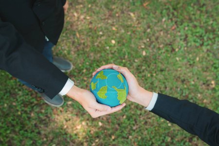 Téléchargez les photos : Concept du Jour de la Terre, vue de dessus homme d'affaires donnant globe Terre comme principe de responsabilité sociale d'entreprise RSE pour promouvoir la sensibilisation à l'environnement et embrasser ESG pour un avenir plus vert et durable. Pneumatique - en image libre de droit