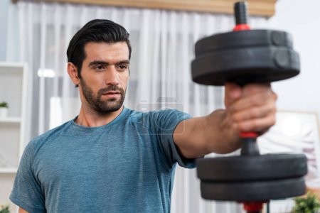 Athletischer Körper und aktiver sportlicher Mann, der Hantelgewicht hebt, um effektiv auf Muskelaufbau zu Hause als Konzept eines gesunden, fitten Körpers zu Hause zu trainieren.