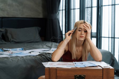 Photo for Stress worried young woman sit at table, as she pay bills online with credit card from financial debt problem, monthly expense and credit card debt. Over spending money lifestyle problem. Blithe - Royalty Free Image
