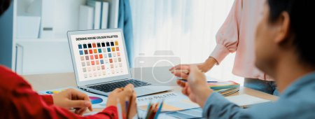 Ein Porträt der Kreativität Grafik-Designer-Team wählen Sie die passende Farbe für das Projekt, indem Sie Laptop auf dem Tisch mit Geräten und Design-Werkzeug herumstreuen in modernen Büros. Nahaufnahme. Bunt gemischt.