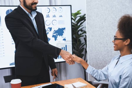 Photo for Diverse coworker celebrate with handshake and teamwork in corporate workplace. Happy business people united by handshaking after successful meeting or business presentation on data analysis. Concord - Royalty Free Image