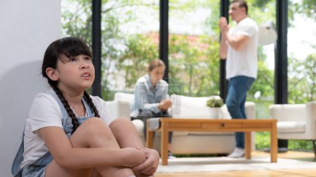 Photo for Stressed and unhappy young girl huddle in corner crying and sad while her parent arguing in background. Domestic violence at home and traumatic childhood develop to depression. Panorama Synchronos - Royalty Free Image