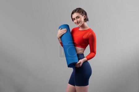 Photo for Full body length gaiety shot athletic and sporty young woman with fitness matt in exercise posture on isolated background. Healthy active and body care lifestyle. - Royalty Free Image