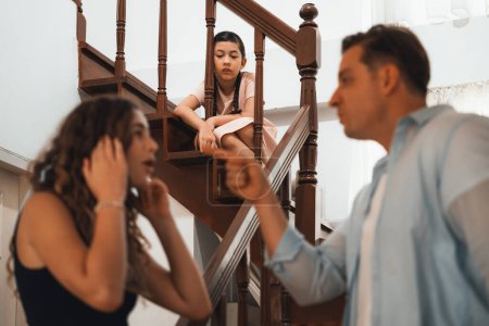 Photo for Stressed and unhappy young girl watch her parent arguing from the stair. Domestic violence at home and traumatic childhood develop to depression and anxiety. Unhealthy family concept. Synchronos - Royalty Free Image