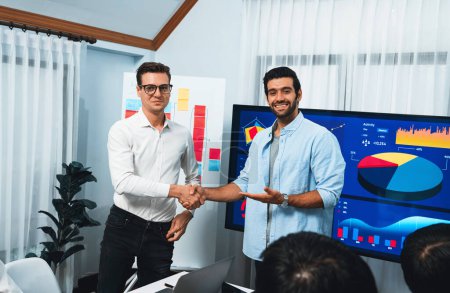 Photo for Analyst team leader shake hand with his colleague after successful data analysis meeting using FIntech software power with business intelligence or BI dashboard. Prudent - Royalty Free Image