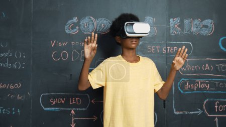 Photo for African student use VR headset learning innovation at metaverse while standing at blackboard with coding or programing prompt written at STEM technology classroom. Creative innovation. Edification. - Royalty Free Image