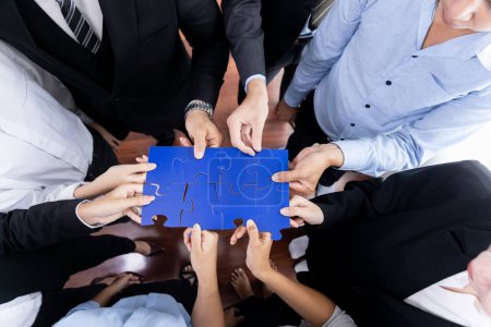 Photo for Top view multiethnic business people holding jigsaw pieces and merge them together as effective solution solving teamwork, shared vision and common goal combining diverse talent. Meticulous - Royalty Free Image
