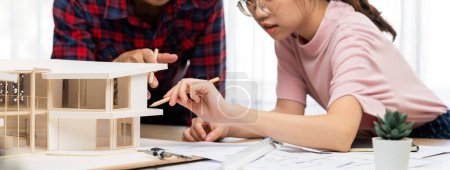 Photo for Smart architect engineer and interior designer working together and measuring house model by using ruler on meeting table with blueprint and architectural equipment. Teamwork concept. Burgeoning. - Royalty Free Image
