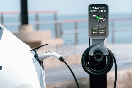 Batterie de recharge de voiture électrique à la station de recharge extérieure EV pour le voyage sur la route ou en voiture voyageant par le paysage marin, technologie d'énergie alternative et durable pour voiture écologique. Perpétuel