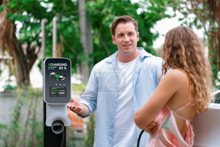 Photo for Happy and lovely couple with eco-friendly conscious recharging electric vehicle from EV charging station. EV car technology utilized as alternative transportation for future sustainability. Synchronos - Royalty Free Image
