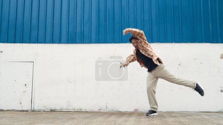 Foto de Coreógrafo divertido hispano bailando en estilo hip hop. Joven bailarina de descanso feliz realizar la danza b-boy. Motion shot de un hombre divertido practicando baile callejero. Deporte al aire libre 2024. Danza moderna. Endeavor. - Imagen libre de derechos