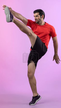 Photo for Full body length gaiety shot athletic and sporty young man with fitness in cardio exercise, kicking position posture on isolated background. Healthy active and body care lifestyle. - Royalty Free Image