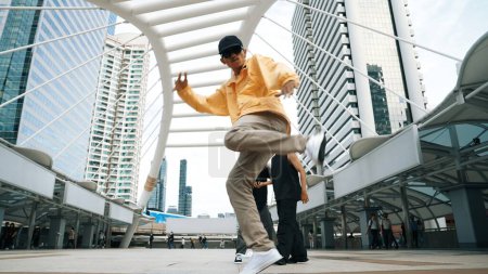 Photo for Group of professional street dancer cheer up while asian hipster perform freestyle footstep at city surrounded by people with low angle camera. Break dance concept. Outdoor sport 2024. Sprightly. - Royalty Free Image