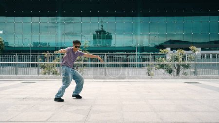 Photo for Skilled asian hipster posing and looking at camera at city urban. Panorama shot of professional street dancer practice b-boy footstep or break dance. Modern lifestyle. Outdoor sport 2024. Sprightly. - Royalty Free Image