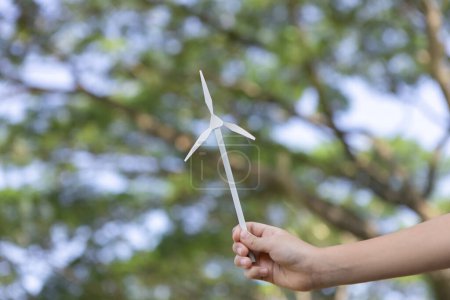 Foto de Pequeño niño sosteniendo molino de viento o modelo de maqueta de turbina eólica para promover la utilización de la tecnología de energía limpia y renovable ecológica para la generación futura y la Tierra sostenible. Gyre. - Imagen libre de derechos