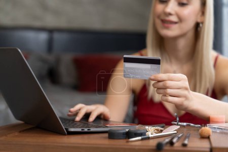 Photo for Young woman using laptop with credit card for internet banking, online shopping E commerce by online payment gateway at home office. Modern and convenience online purchasing with debit card. Blithe - Royalty Free Image