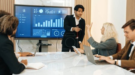 Photo for Presentation in office or ornament meeting room with analyst team utilize BI Fintech to analyze financial data. Businesspeople analyzing BI dashboard power display on TV screen for strategic planning - Royalty Free Image
