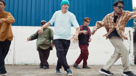 Foto de Grupo de coreógrafos de hip hop bailando danza callejera juntos en la pared. Jóvenes bailarines de break practicando break dance, moviéndose a ritmo moderno, expresan sensación de vivacidad. Exterior 2024. Endeavor. - Imagen libre de derechos