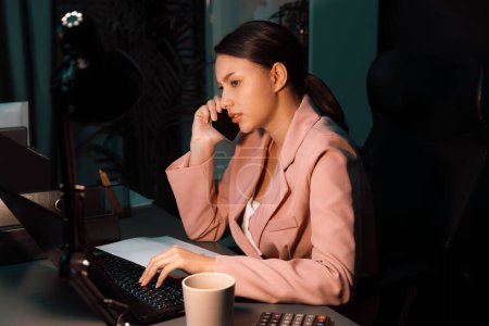 Photo for Serious face of businesswoman calling customer for creative business project planning online marketing for new customer target while working laptop fronted overwork folder at night office. Postulate. - Royalty Free Image