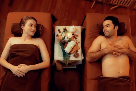 Photo for Panorama top view couple enjoying relaxing anti-stress spa massage and pampering with beauty skin recreation leisure in warm candle lighting ambient salon spa at luxury resort or hotel. Quiescent - Royalty Free Image
