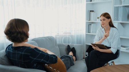 Photo for Happy patient and psychologist exchanging mental health conversation in clinic with positive emotion while explaining prim successful work and life to psychologist at psychologist clinic office - Royalty Free Image