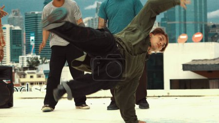 Photo for Professional asian break dancer practice B boy dance while multicultural friends at rooftop. Young modern dancing group doing hip hop movement. Style,fashion,action. Outdoor sport 2024. Endeavor. - Royalty Free Image
