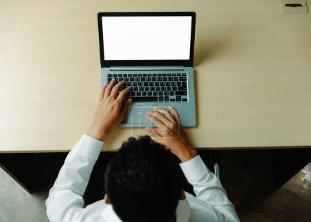 Téléchargez les photos : Un homme d'affaires ou un employé de bureau utilisant un ordinateur portable assis au bureau. uds - en image libre de droit