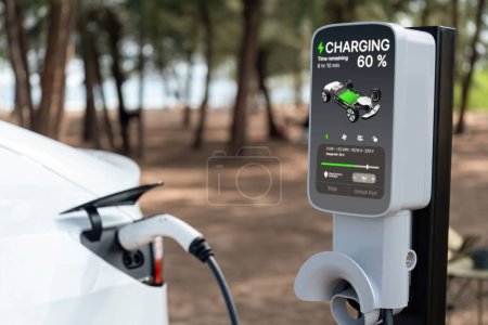 Batterie de recharge de voiture électrique à la station de recharge extérieure EV pour le voyage sur la route ou en voiture voyageant par la plage du paysage marin, technologie d'énergie alternative et durable pour voiture écologique. Perpétuel