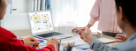 Photo for Cropped image of interior designer team discuss the material color while laptop displayed website wireframe designs for mobiles app and website. Creative design and business concept. Variegated. - Royalty Free Image