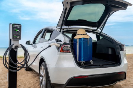 Photo for Road trip vacation traveling to the beach with electric car recharging battery with alternative eco-friendly and clean energy. Natural travel with EV car for sustainable environment. Perpetual - Royalty Free Image