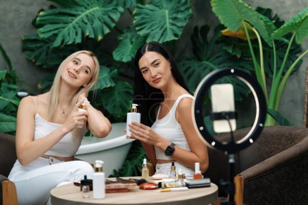 Dos hermosos creadores de contenido haciendo belleza natural y tutorial cosmético en video jardín de plantas verdes. Blogger de belleza mostrando cómo cuidar la belleza a la audiencia social medial usando selfie stick. Blithe.