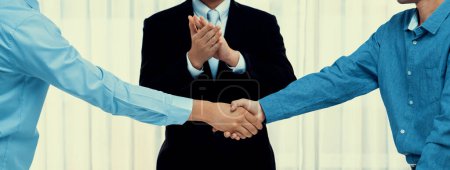 Corporate attorney applaud as business people seal a successful deal or agreement with handshake, celebrating mutually beneficial acquisition. Business handshaking concept. Panorama Rigid