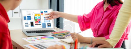 Photo for Cropped image of interior designer team presents color by using color swatches while laptop displayed UI and UX designs for mobiles app and website. Creative design and business concept. Variegated. - Royalty Free Image