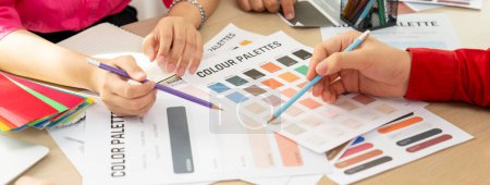 Kreative Interior Designer Brainstorming über die Farbe des Materials. Gruppe von Architekten Designer wählen Farbe sorgfältig durch Verwendung von Farbmustern. Kreatives Design und Teamwork-Konzept. Bunt gemischt.