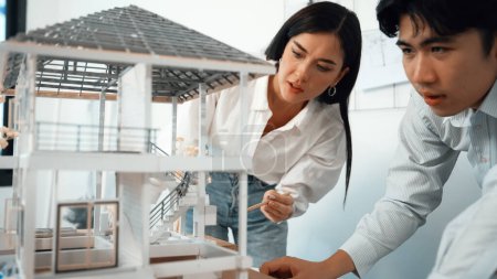 Photo for Closeup of young professional skilled architect engineer team focusing on checking the house model structure at modern office. Creative professional design and teamwork concept. Immaculate. - Royalty Free Image