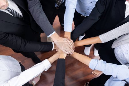 Téléchargez les photos : Les gens d'affaires multiraciaux font synergie main pile ensemble dans la salle de réunion comme coopération ou team building pour les employés de l'entreprise sur le lieu de travail. Méticuleux - en image libre de droit