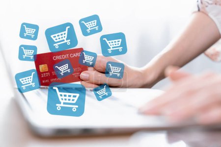 Photo for Elegant customer hold credit card with hologram interface choose online platform. Smart consumer typing laptop while open e-commerce application use cashless technology shopping inventory. Cybercash. - Royalty Free Image