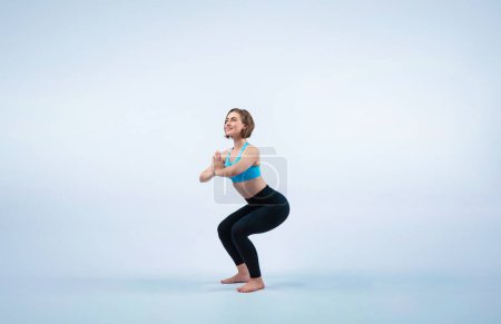 Photo for Full body length gaiety shot athletic and sporty woman doing healthy and meditative yoga exercise workout posture on isolated background. Healthy active and body care lifestyle - Royalty Free Image