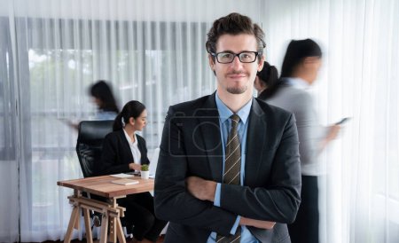 Photo for Portrait of happy businessman looking at camera with motion blur background of business people movement in dynamic business meeting. Habiliment - Royalty Free Image