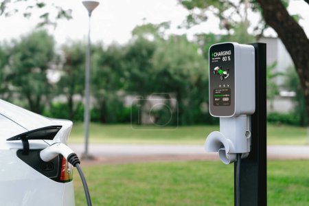 Batterie de recharge de véhicule électrique EV de la station de charge EV dans le parc urbain vert extérieur pittoresque. Protection naturelle avec voiture écologique EV Voyage. Exalt.