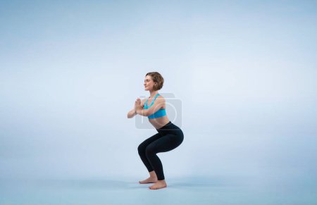 Foto de Gaiety cuerpo entero tiro atlético y deportivo mujer haciendo ejercicio de yoga saludable y meditativo ejercicio postura sobre fondo aislado. Vida sana activa y cuidado corporal - Imagen libre de derechos