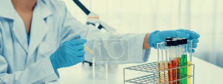 Photo for Laboratory researcher develop new medicine or cure using colorful chemical liquid in lab tube. Technological advance of healthcare with scientific expertise with laboratory equipment. Panorama Rigid - Royalty Free Image